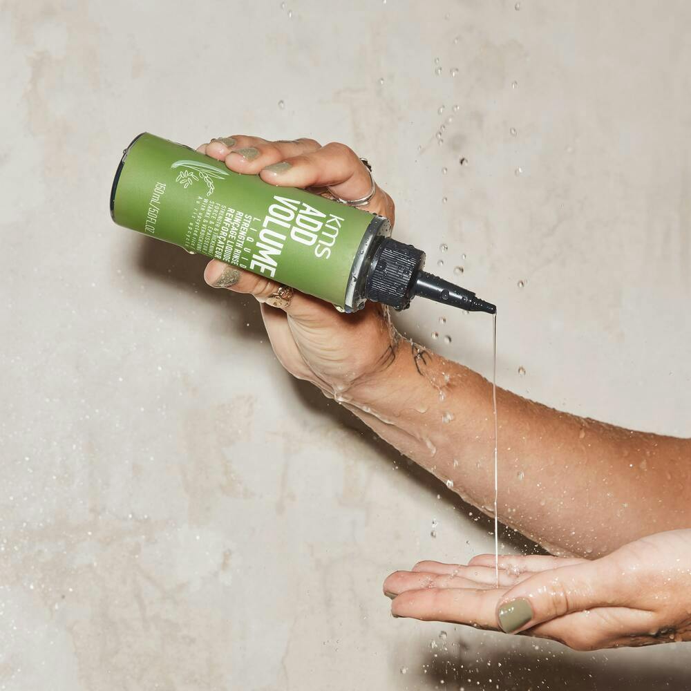 KMS ADDVOLUME Liquid Strengthening Rinse zeigt Produktflasche und Verpackung für kräftigeres Haar